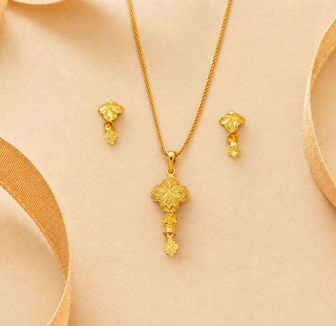 Clover-shaped gold pendant with floral engraving